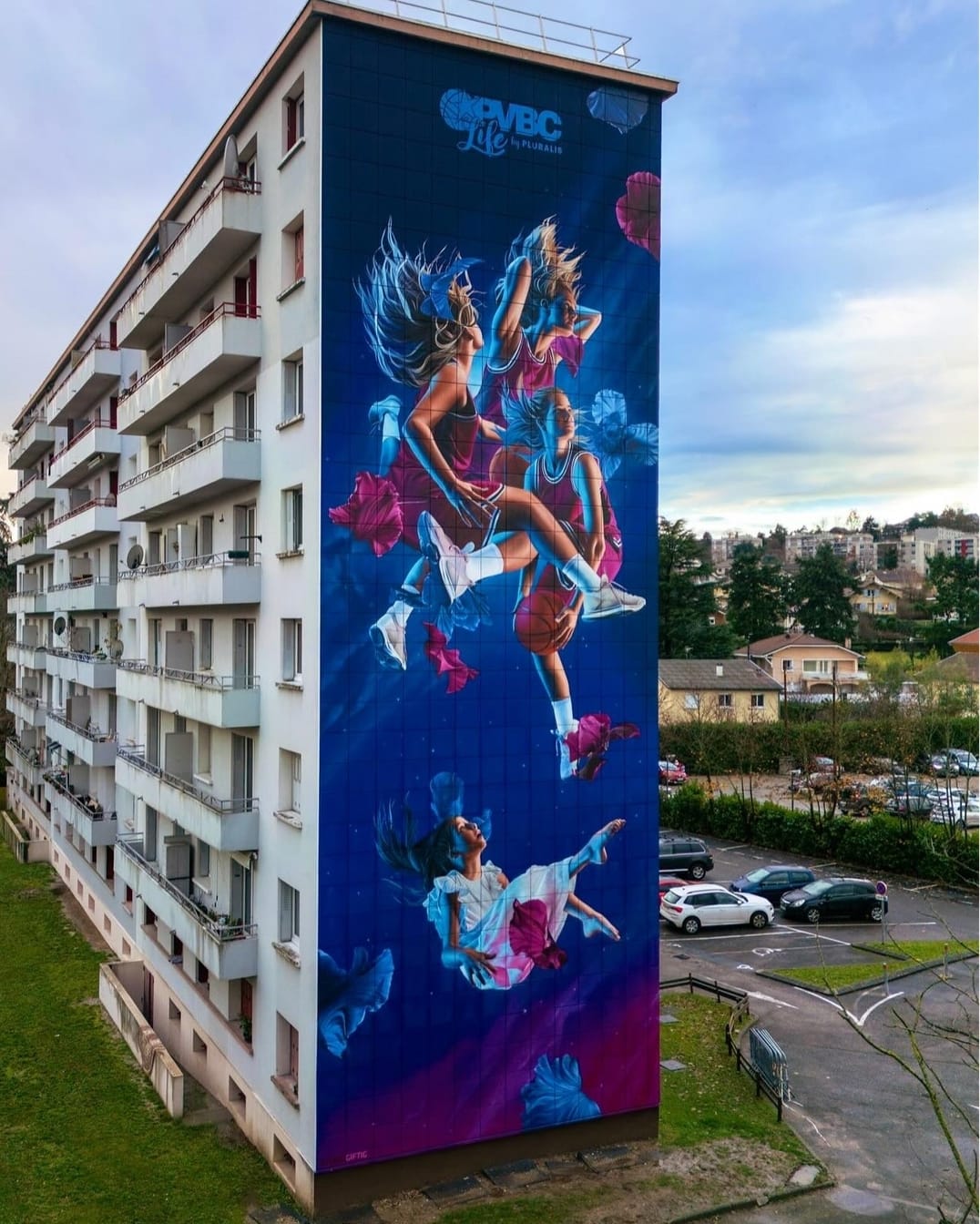 Mural of young women athletes flying, painted on the end of an apartment building in France